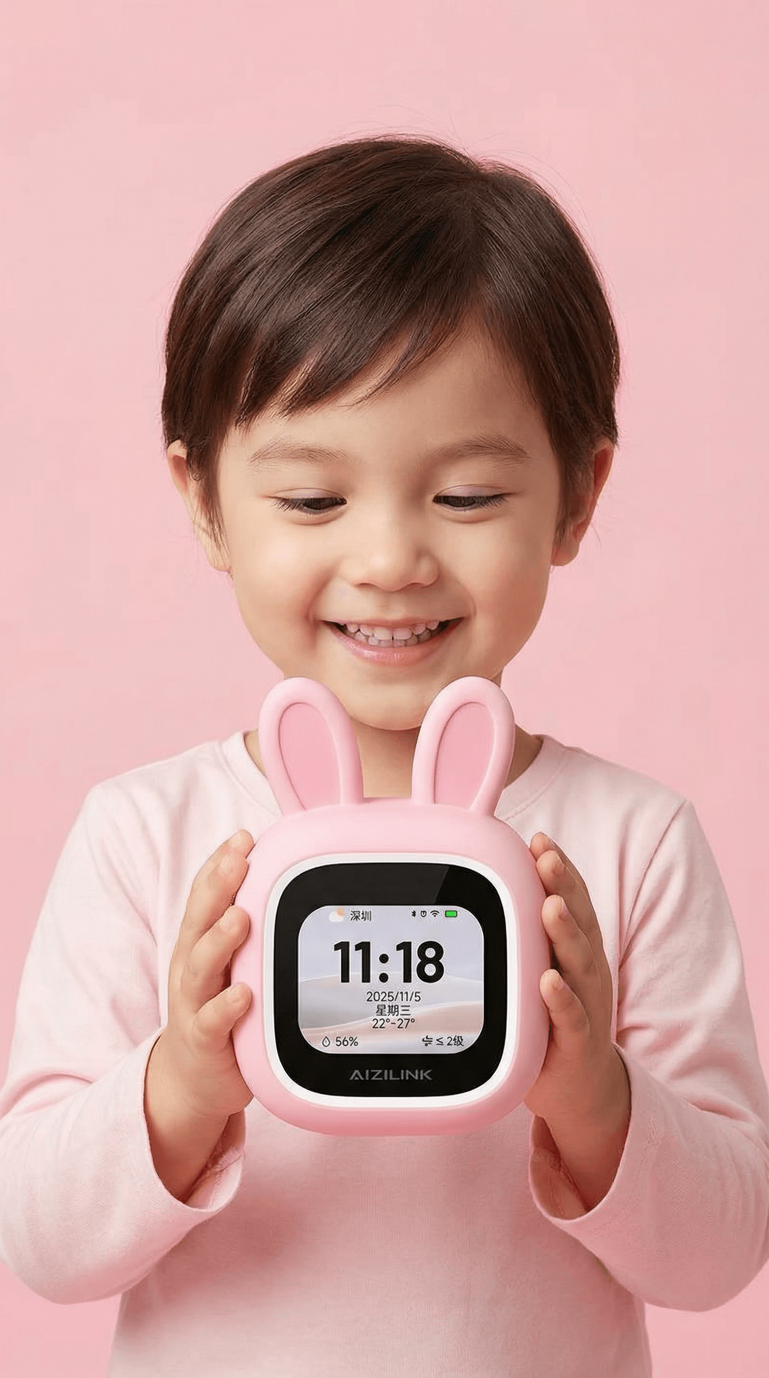 Child holding a pink bunny-shaped smart clock against a pink background